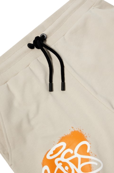 Hugo Boss ανοιχτό μπεζ παντελόνι αθλητικής φόρμας με χαλαρή εφαρμογή με έργα τέχνης γκράφιτι
