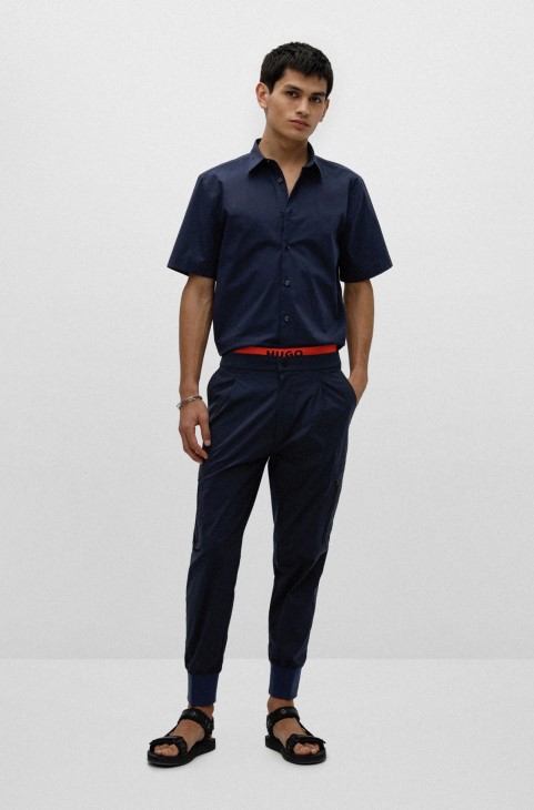 σκούρο μπλε παντελόνι με μανσέτες με λεπτή εφαρμογή με κόκκινο λογότυπο ετικέτα Hugo Boss
