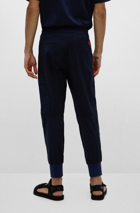 σκούρο μπλε παντελόνι με μανσέτες με λεπτή εφαρμογή με κόκκινο λογότυπο ετικέτα Hugo Boss
